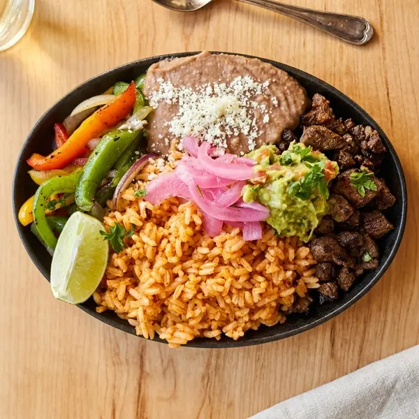 Carne asada platter with Mexican rice, house beans, guacamole and pickled onion at MEXIKAN in Chappelle, Edmonton